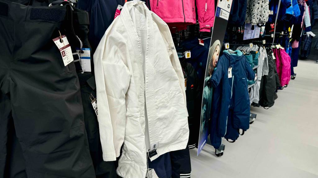 Der getestete Judoanzug hängt in einem Regal vor anderen Kleidungsstücken.
