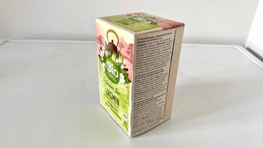 Auf einer hellen Fläche steht eine Packung Jasmintee leicht seitlich.