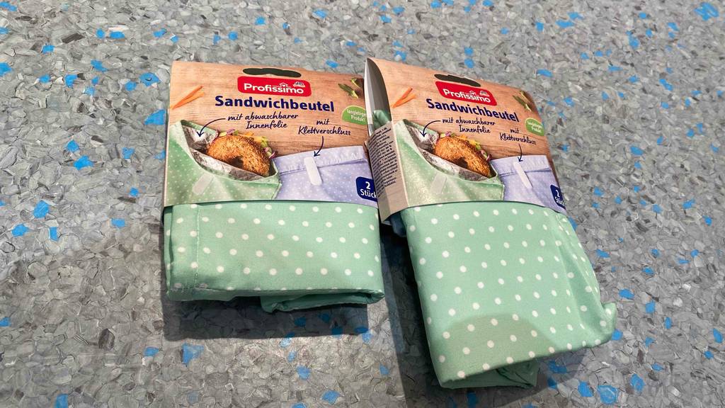 Brotbeutel getestet: Zwei Packungen liegen nebeneinander auf einer blaugrauen Fläche.
