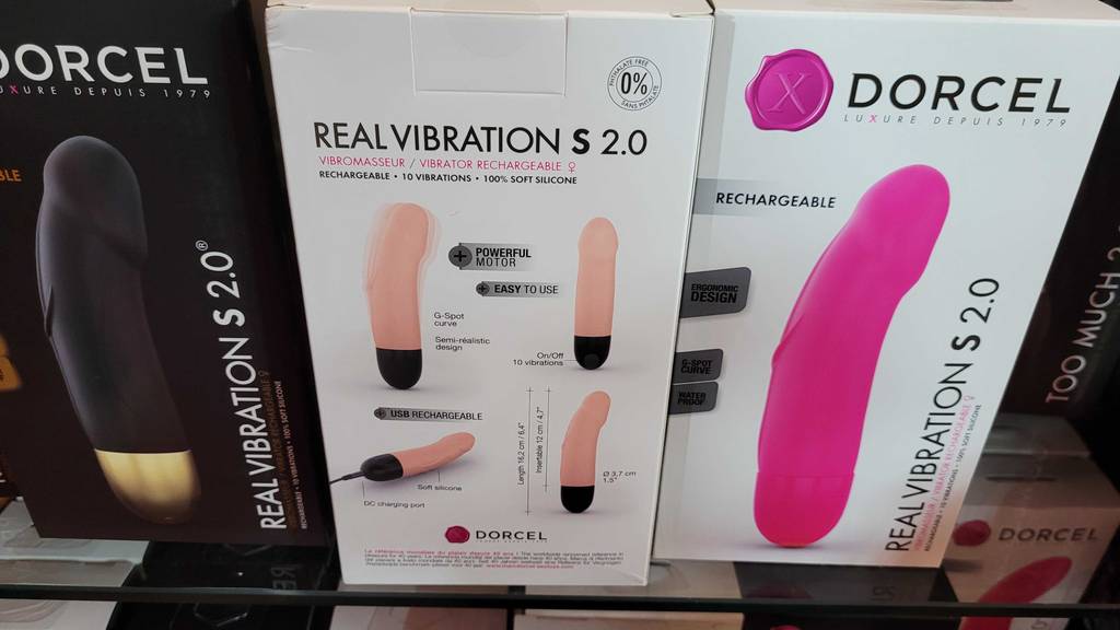 In einem Regal neben anderen Produkten steht ein getesteter Vibrator in seiner Originalverpackung.