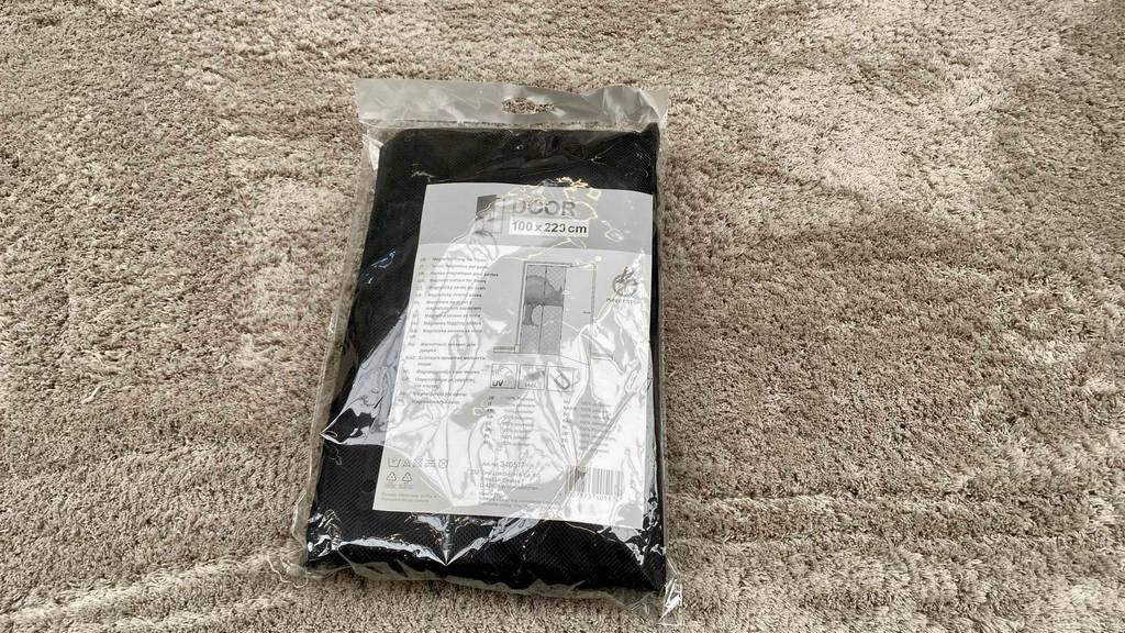 Fliegengittertüre getestet: eine Fliegengittertüre liegt in der Verpackung auf einem Teppich.
