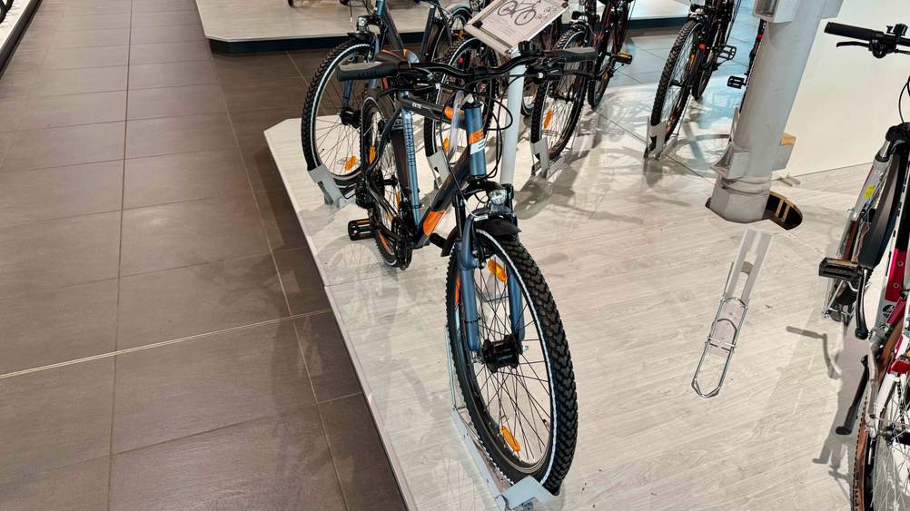 Das getestete Mountainbike bis 500 Euro steht auf einer Plattform, worauf auch andere Mountainbikes stehen.