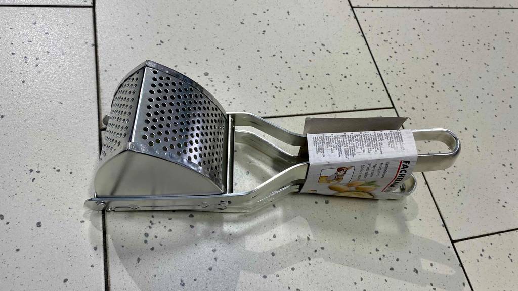Kartoffelpresse getestet: Kartoffelpresse liegend auf einem Boden - Löcher der Kartoffelpresse ersichtlich.