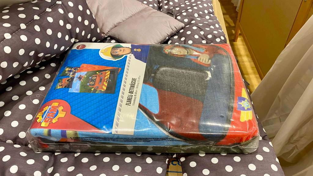 Flanell-Bettwäsche-Test: Auf einem gepunkteten Untergrund liegt eine verpackte Flanell-Bettwäsche.