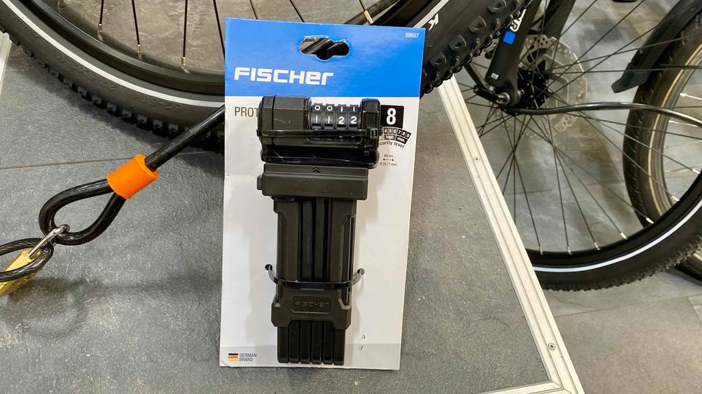 Faltschloss-Zahenschloss im Test: ein Faltschloss-Zahlenschloss steht vor einem Fahrrad.