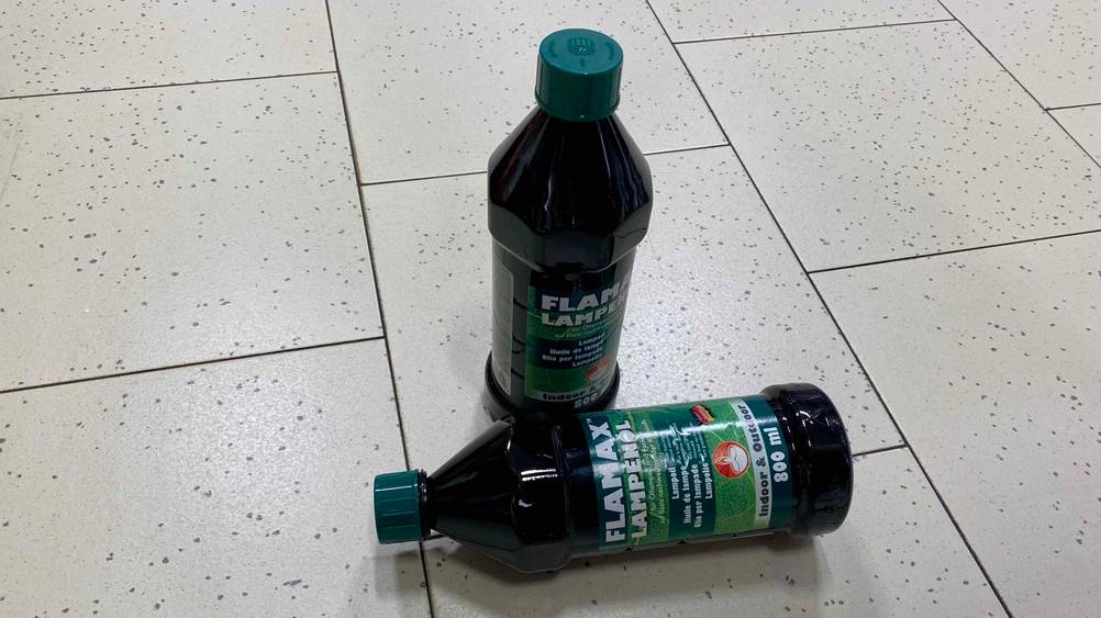 Lampenöl getestet: eine stehende und eine liegende Lampenölflasche am Boden platziert.