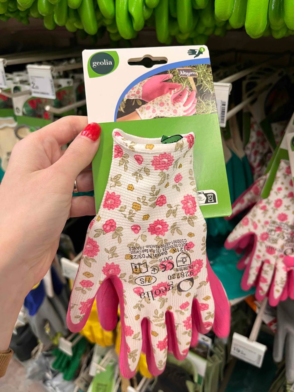 Schnittschutzhandschuhe getestet: Eine Hand hält einen Handschuh der im Regal hängt
