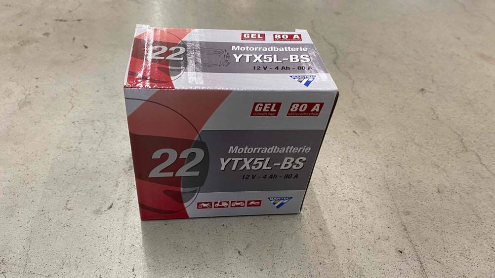 Auf einer hellen Oberfläche steht eine getestete Motorrad-Batterie.