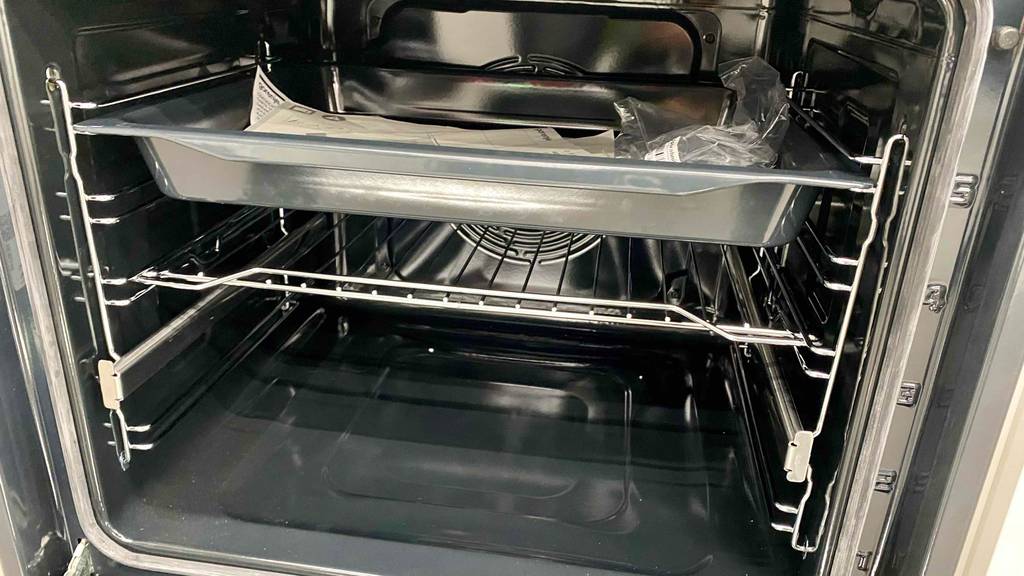 Backofen-300-Grad-Test: Innenaufnahme eines Backofens mi Bleche und dazugehörige Betriebsanleitung befindet.