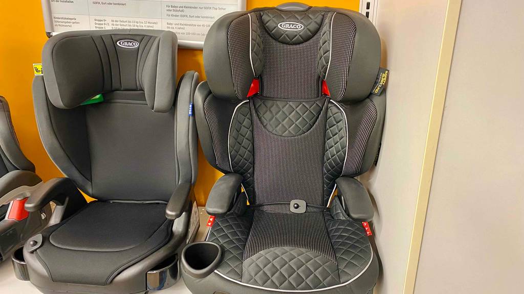 Ein getesteter Kindersitz ab 4 Jahren von vorne neben anderen im Regal.