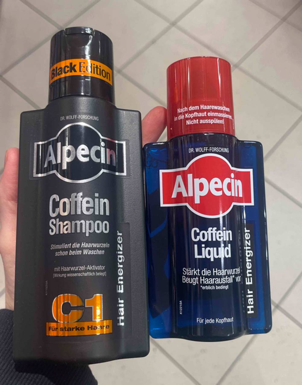 Haarwachstum-Shampoo-Test: Ein Coffein-Shampoo und ein Coffein-Liquid werden in der Hand gehalten.