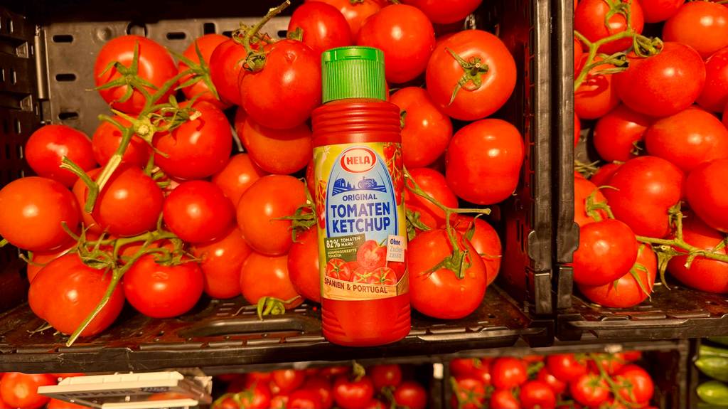 Test: Eine Flasche Hela-Ketchup ist auf frischen Tomaten platziert.