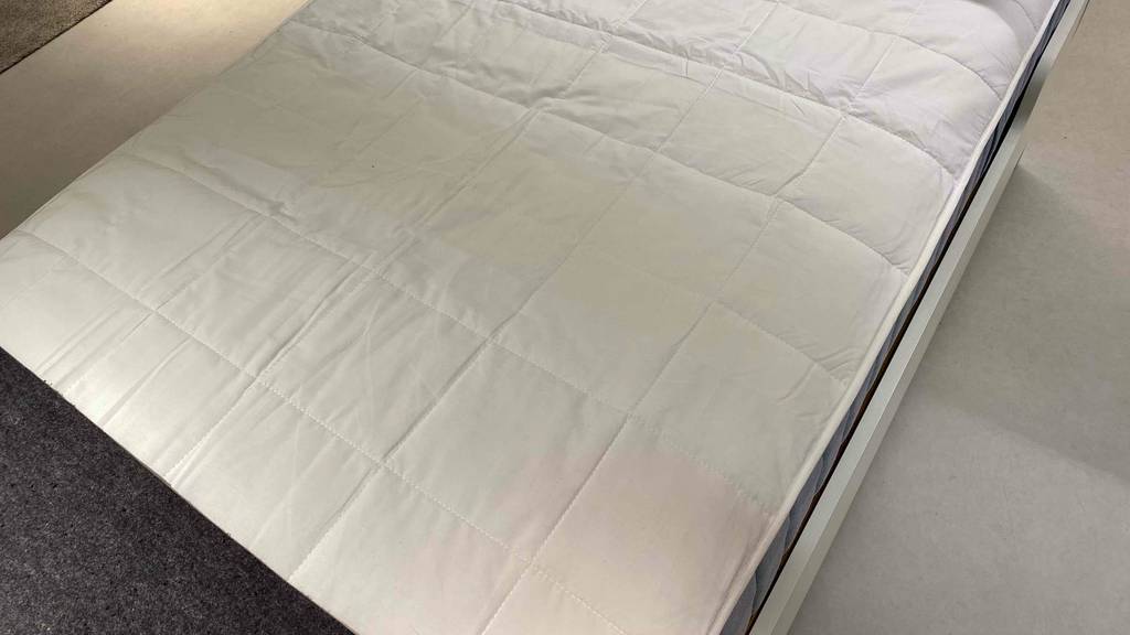 Matratzenschoner getestet: unterer Teil eines Matratzenschoners auf einem Bett fixiert.