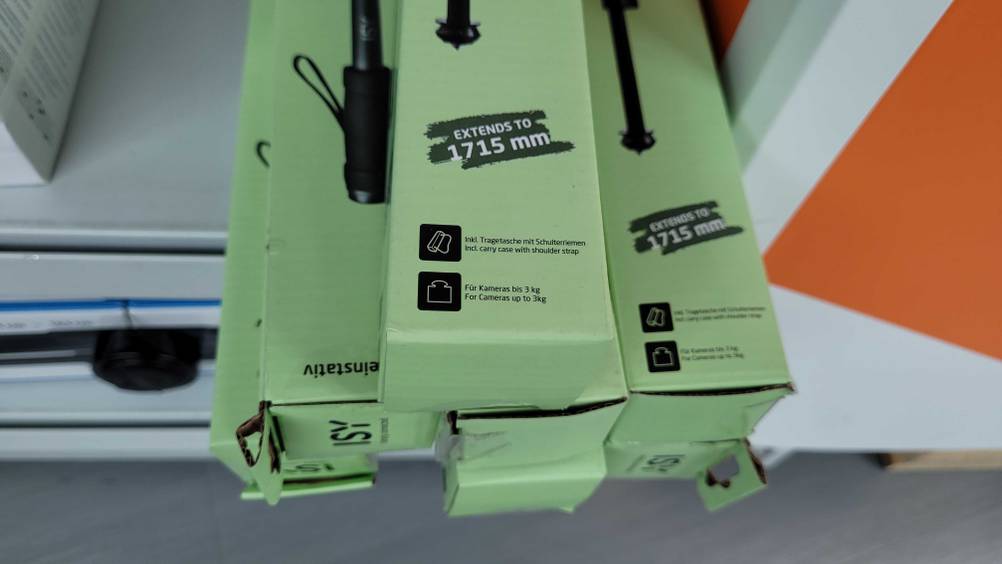 Einbeinstativ im Test: unterer Teil der Verpackung eines Einbeinstativs im Fokus mit Informationen zur Tragkraft und Zubehörteile.