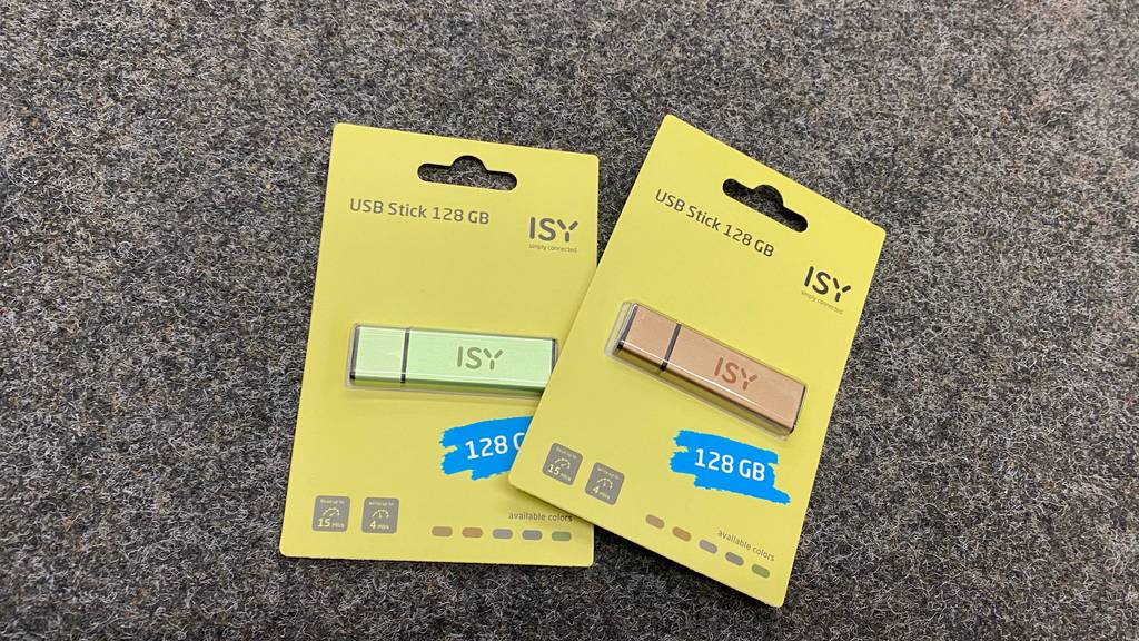USB-Stick (128 GB) getestet: Zwei verpackte Sticks leicht übereinander auf einem grauen Teppich liegend.