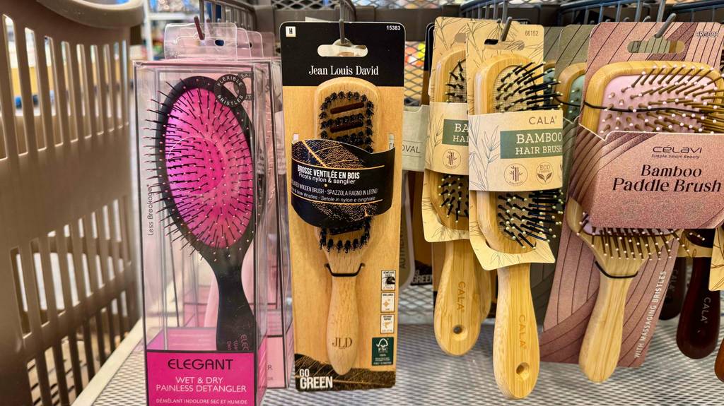 Die getestete Holz-Haarbürste hängt neben anderen Haarbürsten in einem Regal.