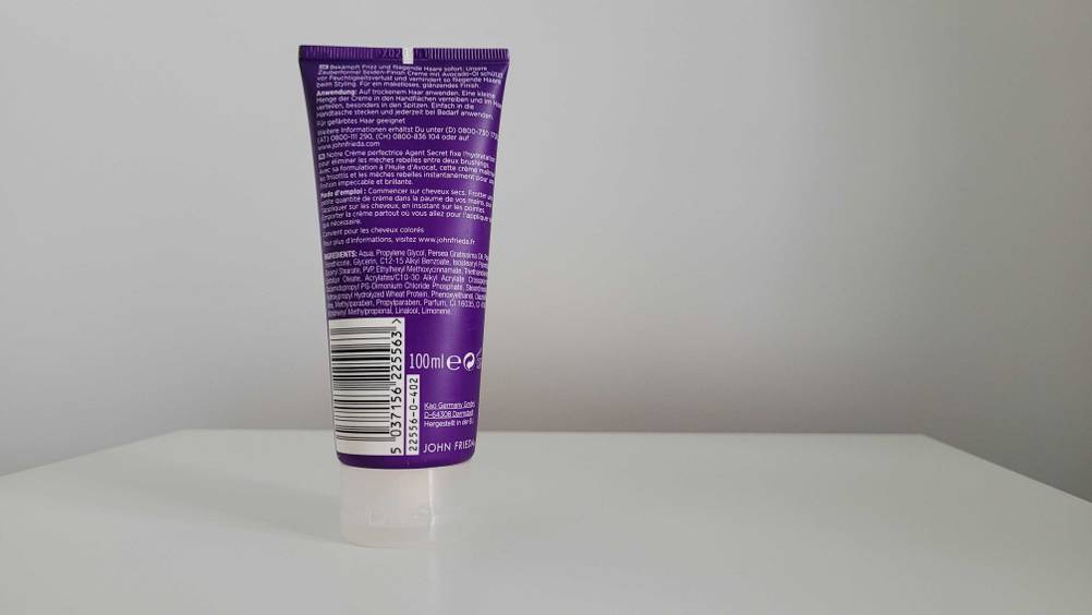 Rückseite einer getesteten Haarcreme vor einer hellen Wand.