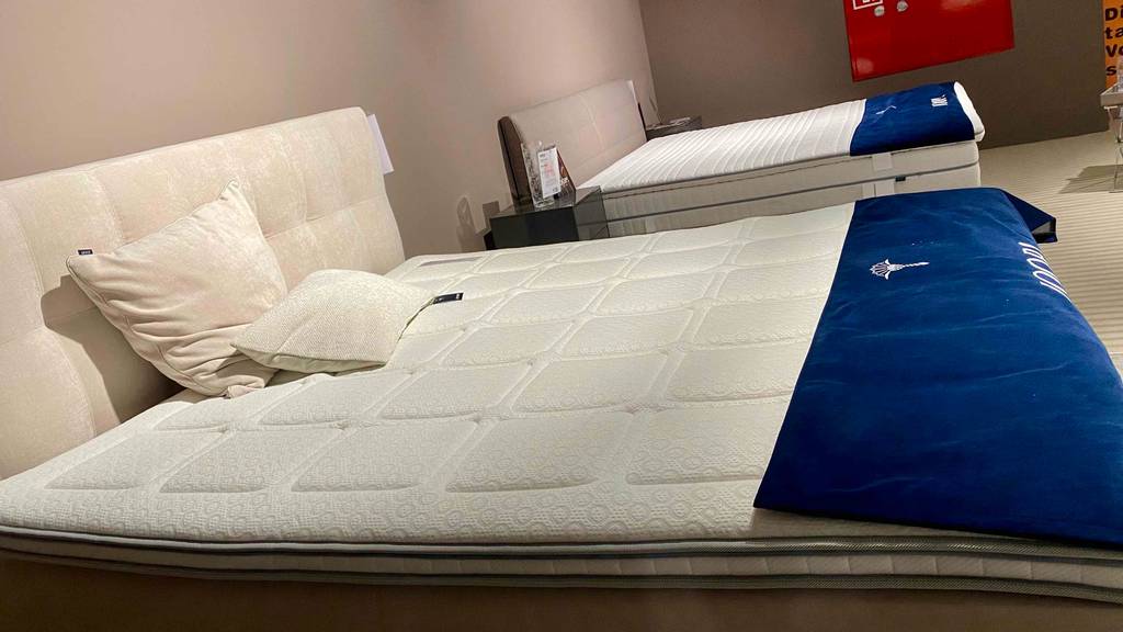 Kaltschaum-Topper getestet: ein Kaltschaum-Topper auf einem Bett platziertmit Kissen darauf.