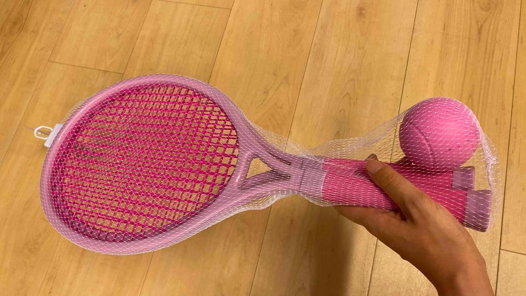 Tennisschläger-Kinder Test: Zwei rosafarbige werden in einer Hand gehalten.