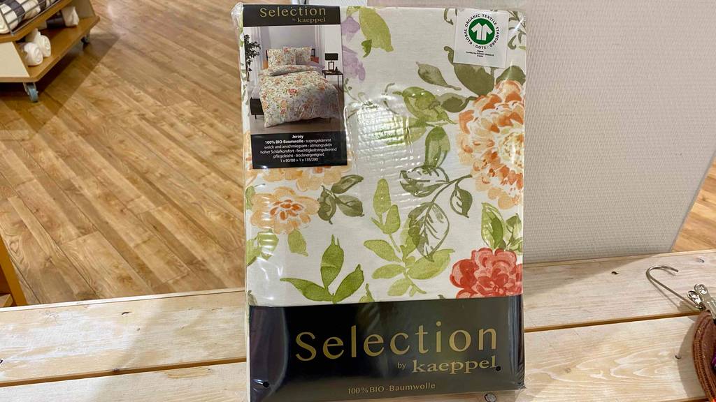 Im Test: Eine verpackte Jersey-Bettwäsche lehnt an einem weißen Brett.