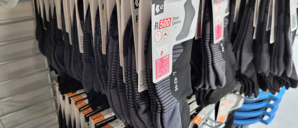 Mehrere Packungen der getesteten Laufsocken hängen in einem Geschäft in einem Regal.