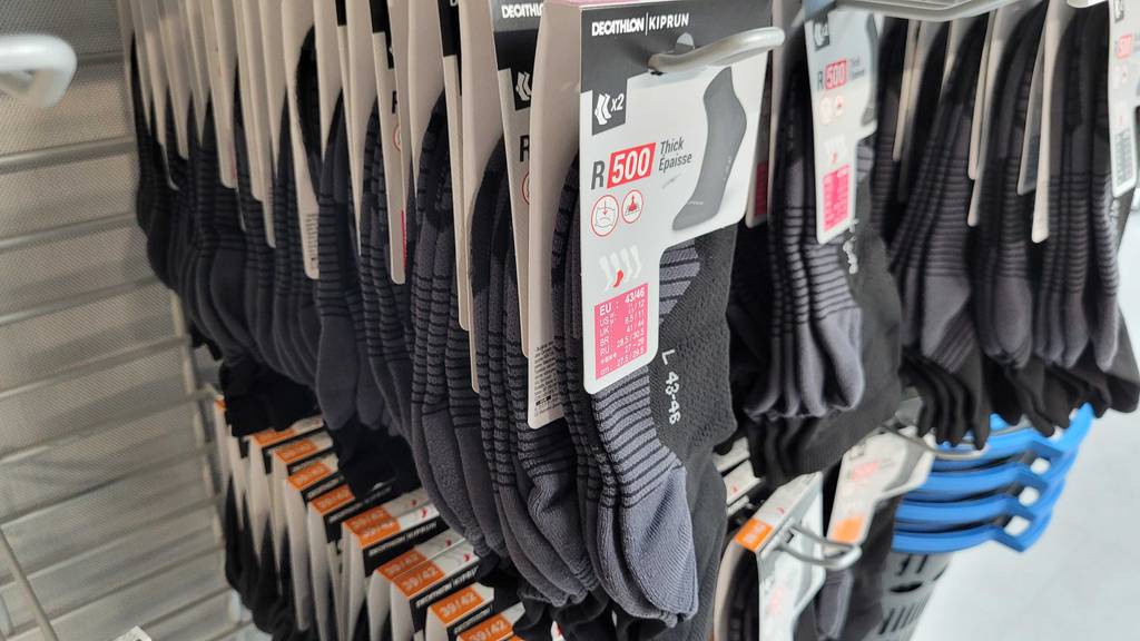 Mehrere Packungen der getesteten Laufsocken hängen in einem Geschäft in einem Regal.