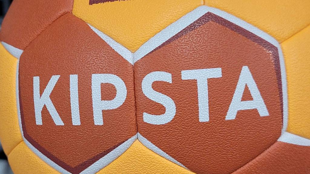 Im Test: ein Handball Größe 0 in Gelb-orange von Kipsta im Detail.