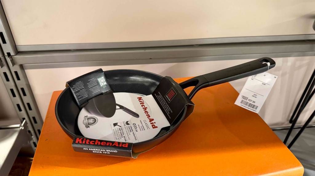 Eine KitchenAid-Pfanne steht auf eomem orangen Hocker.