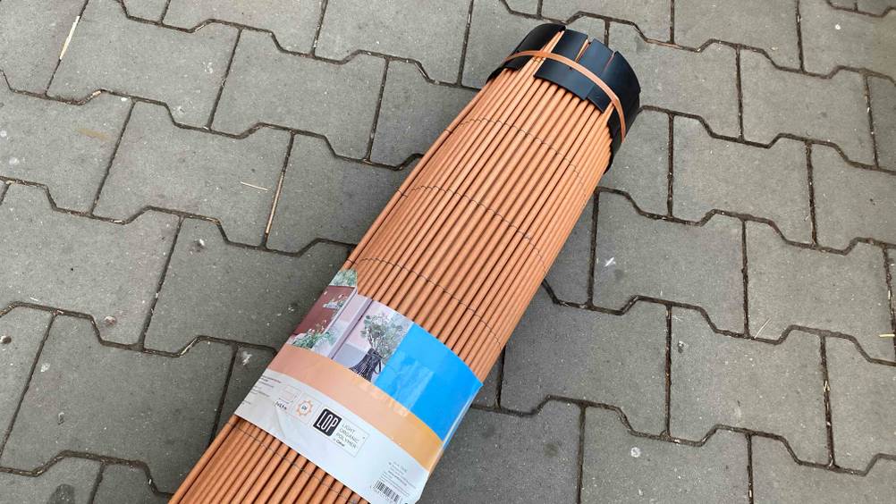 Balkon-Sichtschutz getestet: Ein Balkon-Sichtschutz liegt auf einem Boden mit einer Schutzkappe darauf.