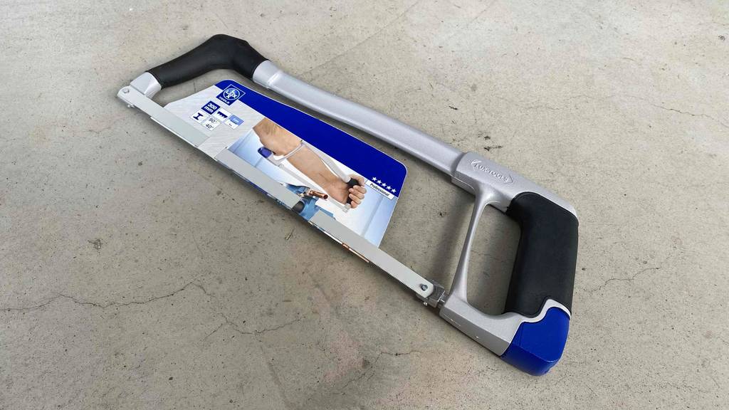 Getestete Metallsäge liegt auf einem Steinboden