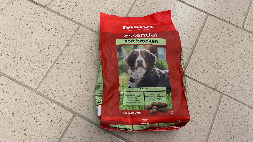 Auf einem hellen Fließenboden liegt eine Packung getestetes Mera-Hundefutter