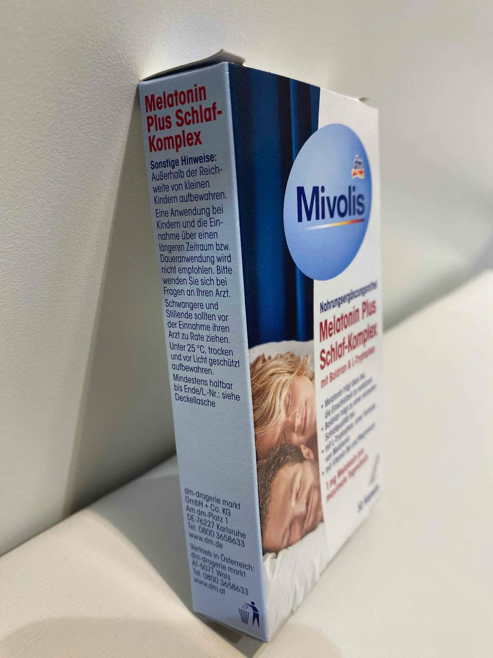 Die Verpackung der getesteten Melatonin-Kapseln lehnt an einer weißen Wand.