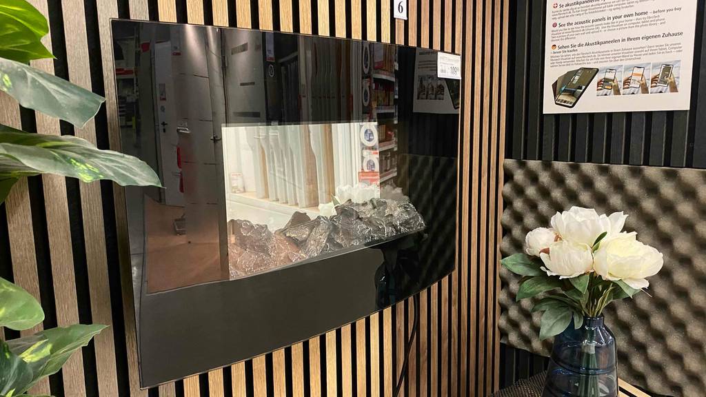 Elektro-Wandkamin im Test: ein Elektro-Wandkamin mit schwarzer Umrandung an einer Wand hängend.