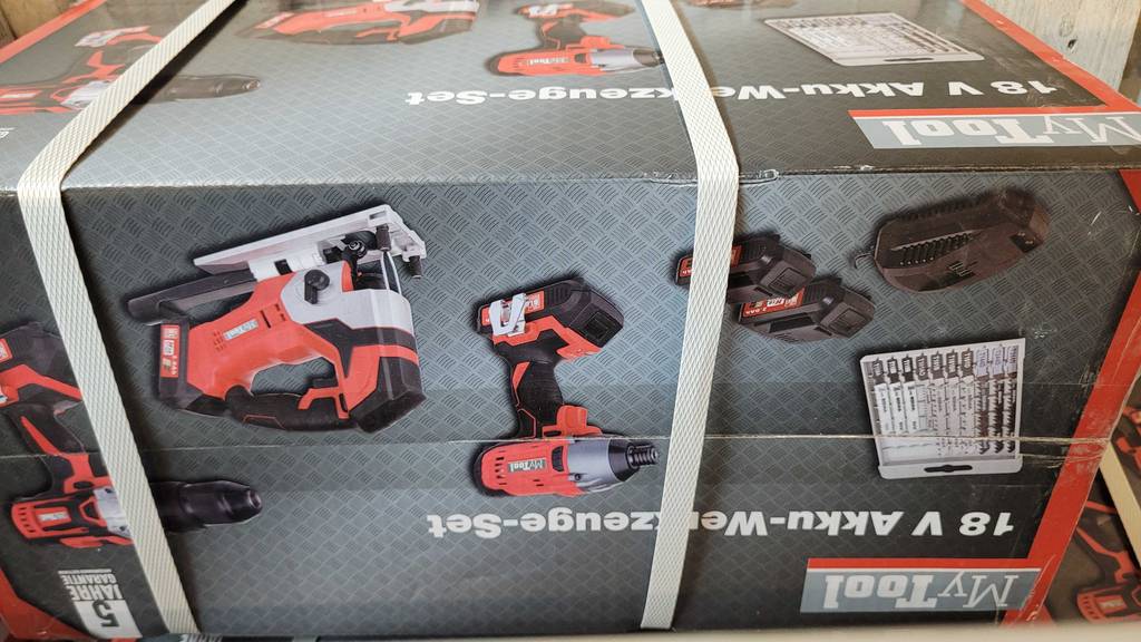 Getestet: Die Verpackung eines Akku-Werkzeug-Sets mit Kabelbindern fixiert und verschiedene Zubehörteile darauf zu sehen.