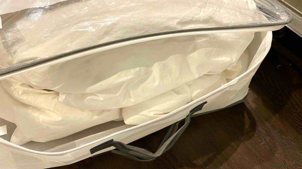 Daunendecke-155x200 im Test: eine geöffnete Aufbewahrungstasche einer Daunendecke mit Fokus auf den Reißverschluss.