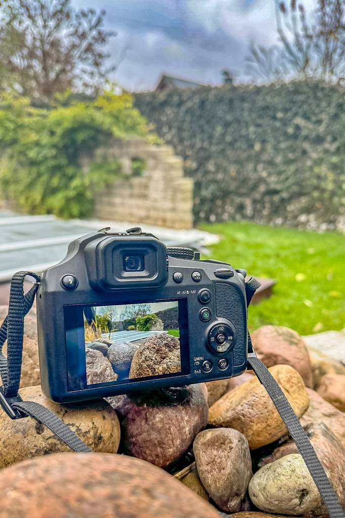 Die getestete Reisezoom-Kamera wurde in einem Außenbereich zum fotografieren aufgestellt, mit Blick auf das Display.