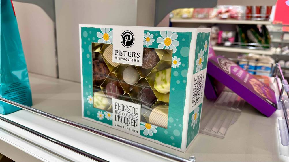 Die getesteten Peters-Pralinen, die sich in der transparenten Verpackung befinden, stehen in einem Regal.