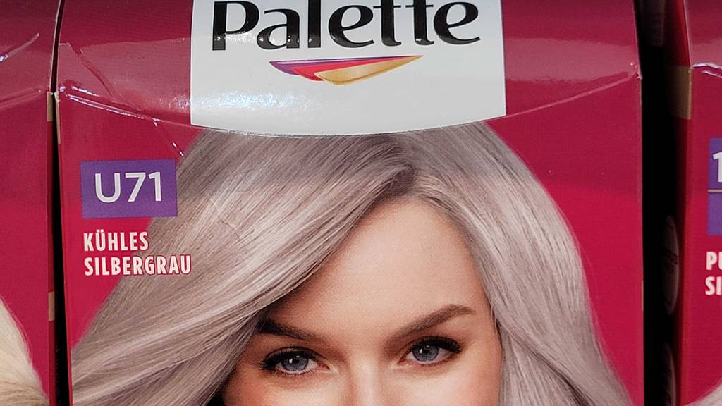 Silber-Haarfarben im Test: Ansicht der silbergrauen Haare einer Frau auf der roten Verpackung.