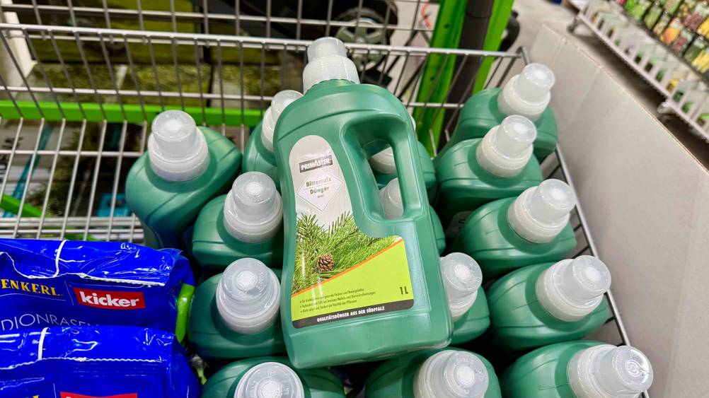 Mehrere getestete Bittersalz-Dünger sind in einem Korb einsortiert, wobei eine Flasche darauf liegt.