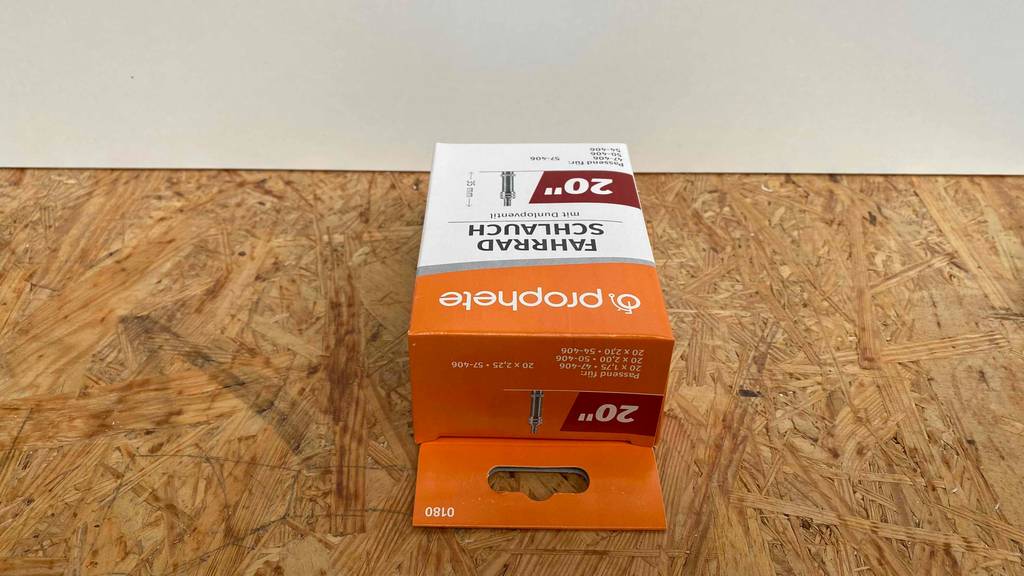 Fahrradschlauch im Test: orangefarbige Verpackung verschlossen liegend.