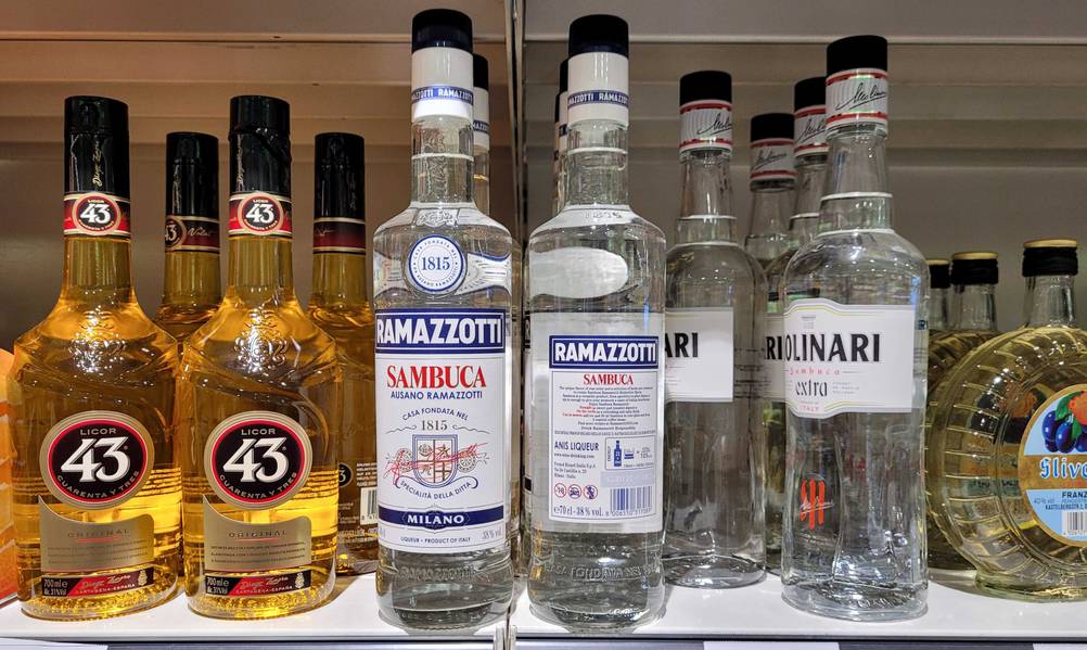 Getestete Flaschen Sambuca in einem Regal mit mehreren anderen Flaschen