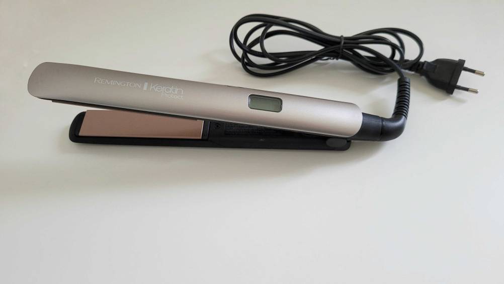 Ein getestetes Remington-Glätteisen von schräg oben mit Kabel auf einer hellen Fläche.