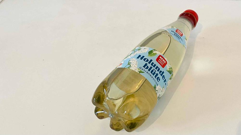 Nahaufnahme des Bodens einer Flasche getesteten holunderbluetensirups.