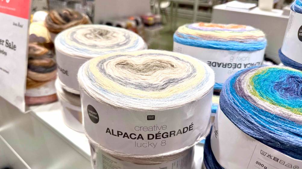 Alpakawolle-Test: Alpakawolle in verschiedenen Farben sind auf einem Tisch in einem Geschäft platziert.