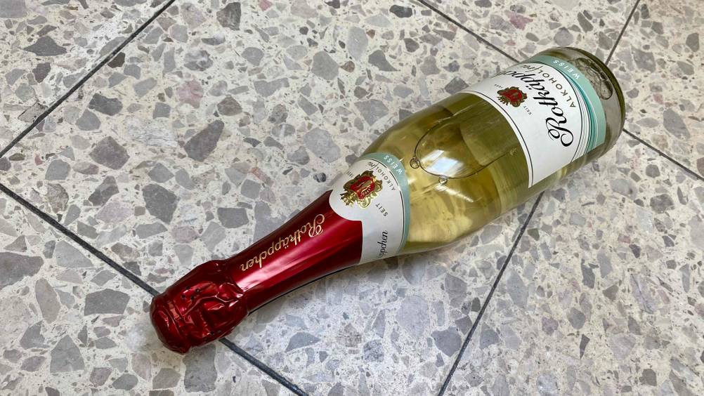 Alkoholfreier Sekt getestet: Eine Flasche liegt quer auf einem Fließenboden