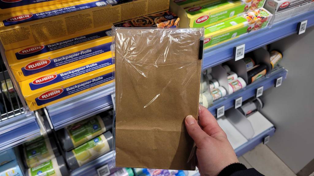 Verpackung von getesteten Papiertüten werden in der Hand gehalten - mit der Rückseite ersichtlich.