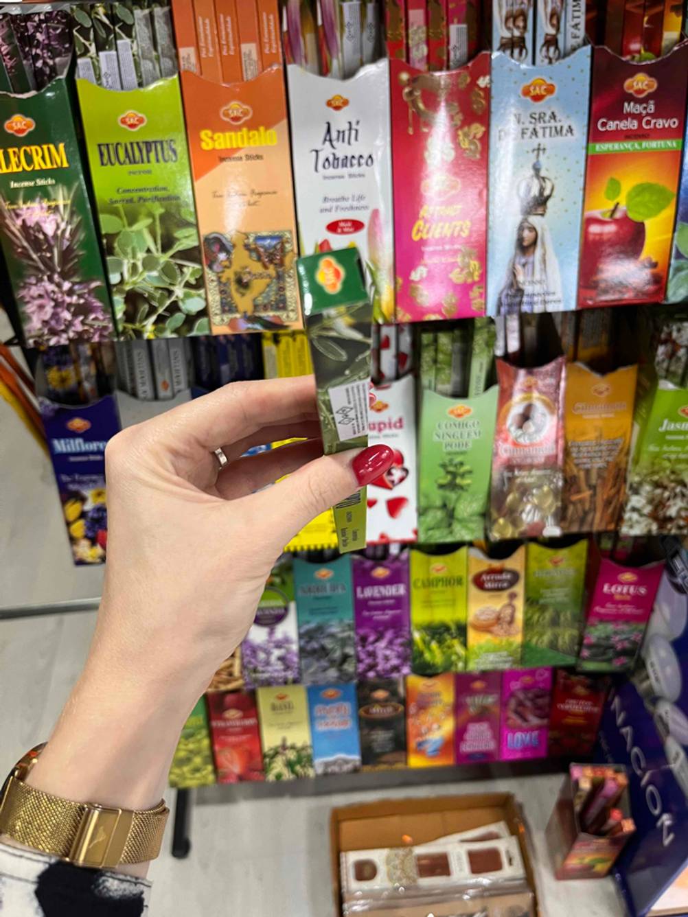 Räucherstäbchen im Test: Eine Hand hält eine Packung vor ein Regal