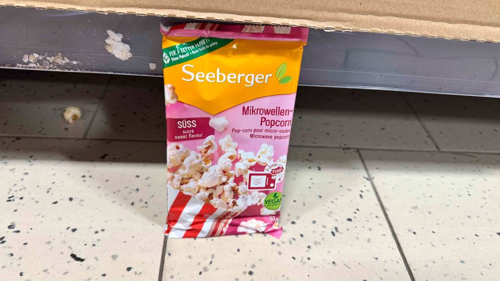 Getestete Mikrowellen-Popcorn stehend vor einem Regal in einem Geschäft.