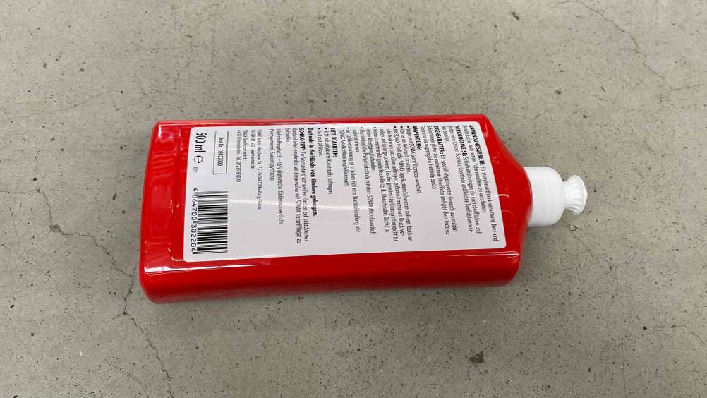 Lackreiniger im Test: Eine Flasche liegt mit Rückseite nach Oben auf einer Steinfläche