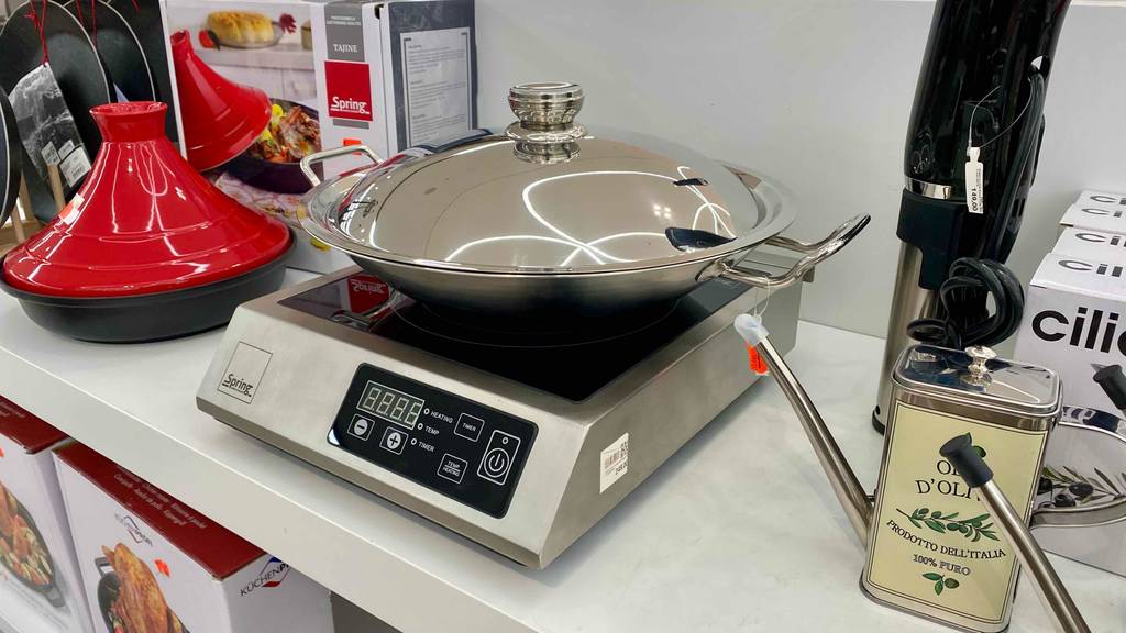 Ein getesteter Elektro-Wok in einem Geschäft neben anderen Produkten platziert.